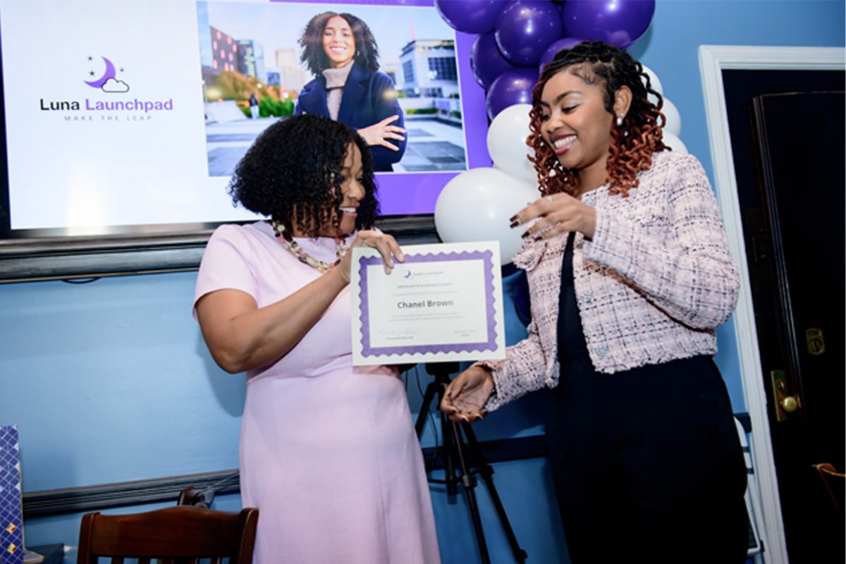 Black woman receiving graduation certificate